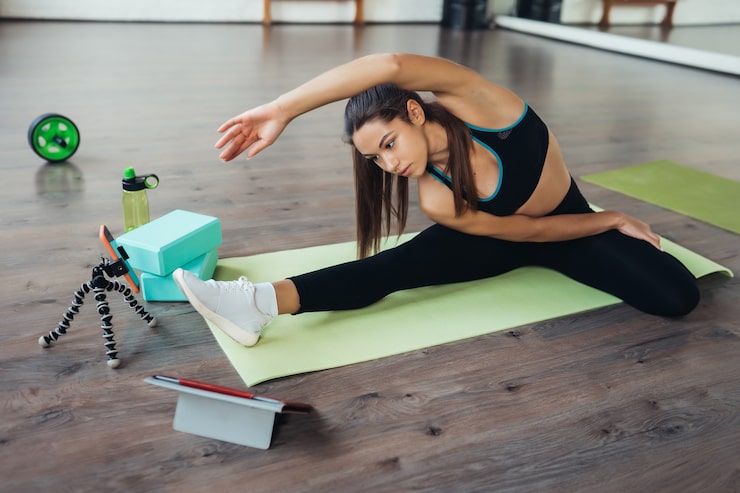 Person performing flexibility exercises with resistance bands and foam roller in a home gym